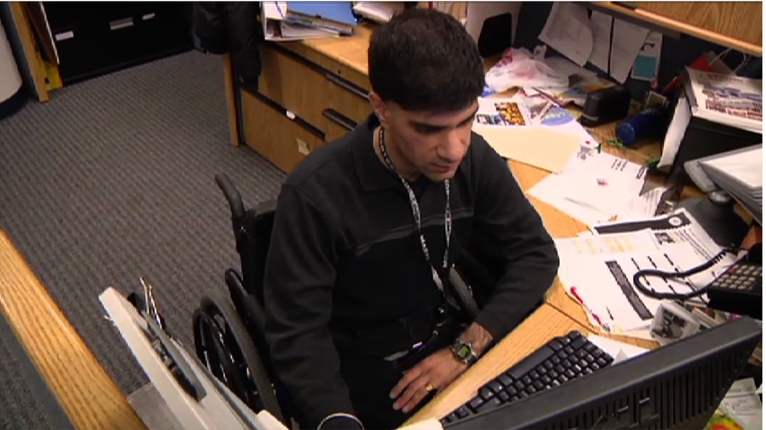 Man in wheelchair working at desk