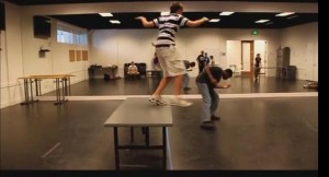 Image of young student jumping off table