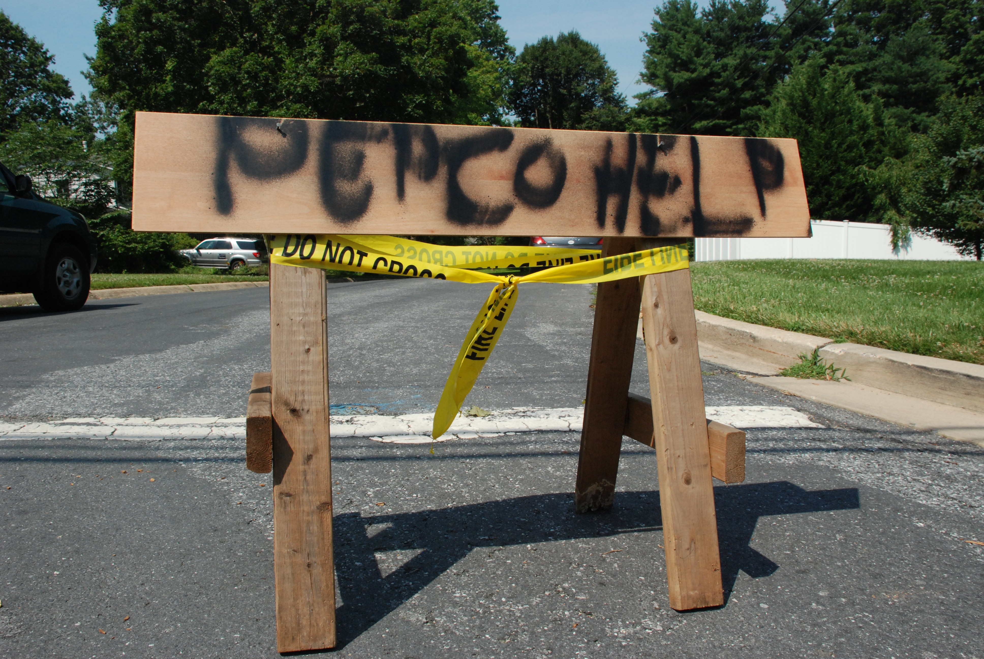 Image of a wooden horse with the words "Pepco help" sprayed painted in it at ebd of street in Aspen Hill, MD