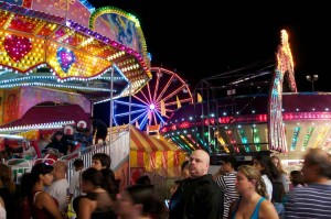 image of Night at the Fair. Bright lights attracted large crowds on the mid-way.