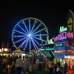 Image of Fair rides and ferris wheel at night