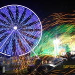 Image of ferris wheel and fair rides at night that looks like sparks