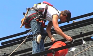 photo man installing solar panels on roof