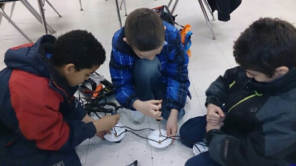 Electricians Devon, Elijah and Raneem wire the footlights.  