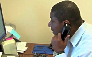 photo man taking phone call at desk with computer