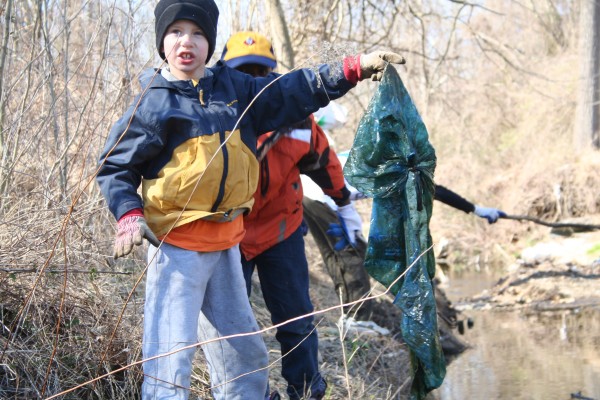photo of boy cleaning up stream