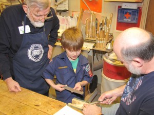 photo of seniors and cub scout working on pine derby in woodshop