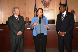 photo of Councilmember Phil Andrews (left) and Council President Craig Rice presented a proclamation to Dr. Handy-Collins (center) on behalf of the Council.