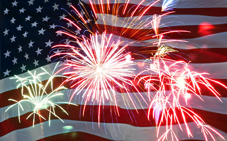 photo of fireworks in with US flag in background