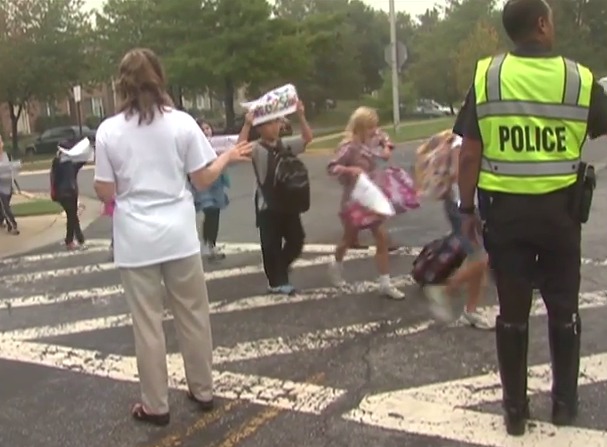 photo of school children crossing street with crossing guard