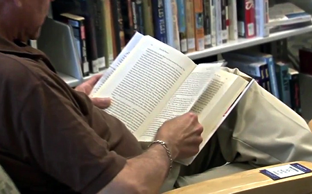 photo of man reading in library