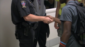 photo of school resource officer shaking hands with student