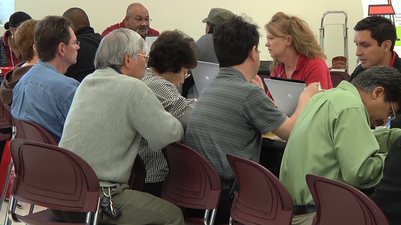 photo of people attending resource fair and getting assistance at a table