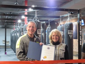 John Sahakian, owner, Title Boxing Club is presented with the County Executive certificate by Kathleen Mayer, senior vice president, Monument Bank & GGCC board member.