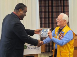 The Riderwood Lions Club was recognized for its community service during a volunteer appreciation luncheon held at the Erickson Living retirement community on Friday, February 13.  In turn, the Club honored five employees from Riderwood who assist in a service project supporting Shepherd’s Table of Silver Spring.  On the left is Reggie Dennis, Housekeeping Manager, receiving a plaque from Ken Kennedy, Project Coordinator for the Riderwood Lions Club.