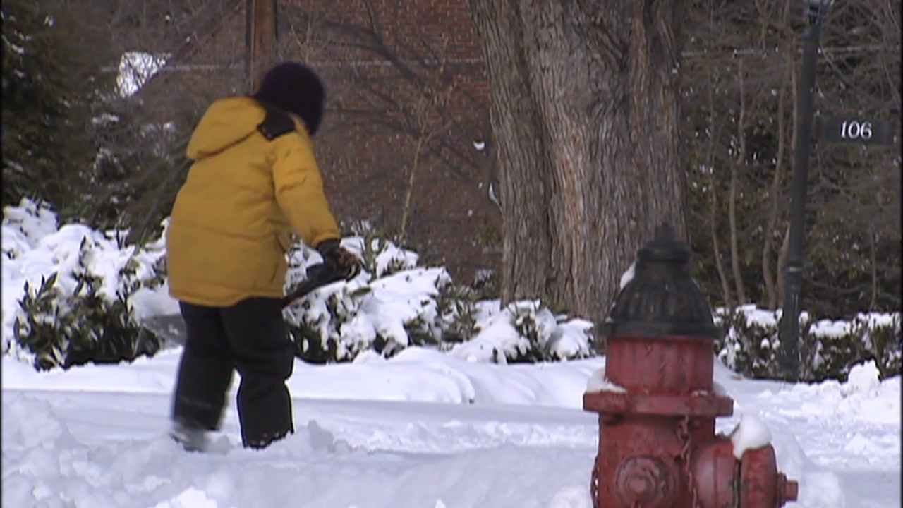 photo of resident shoveling snow from sidewalk after winter storm