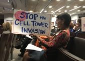 A resident holds a sign at Tuesday night's cell tower hearing.