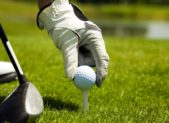 feature golf close-up-of-hand-placing-golf-ball-on-tee-with-golf-club-picture-id105937462